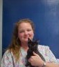 Ruthann - Client Care Specialist hold a black cat