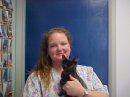 Ruthann - Client Care Specialist hold a black cat